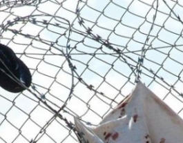 Foto: José Palazón. Zapatos y camisetas en la valla de Melilla