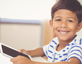 Un nen agafa una tablet a casa per poder continuar amb la seva rutina escolar. Font: Fundació IRES