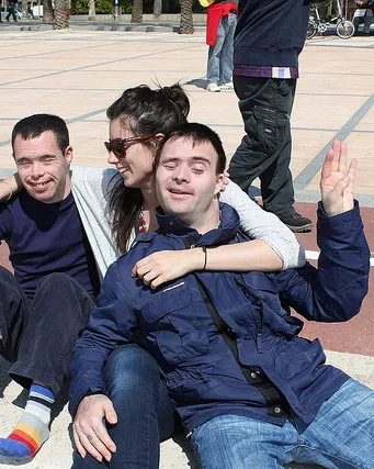 Monitor amb joves amb discapacitat intel·lectual fent una activitat en un pati d'escola