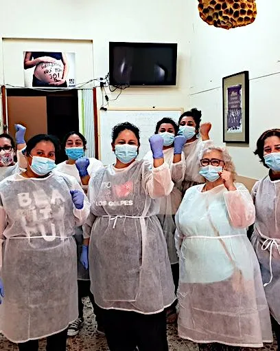 Dones de l'associació Mujeres Migrantes Diversas repartint cistelles de productes bàsics i material de protecció. 