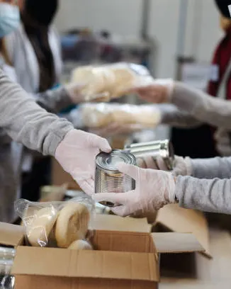 Persones voluntàries preparant caixes amb aliments