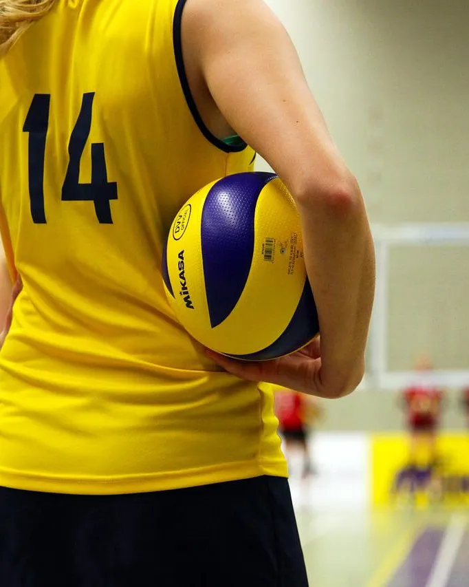 Noia amb una pilota de voleibol jugant un partit