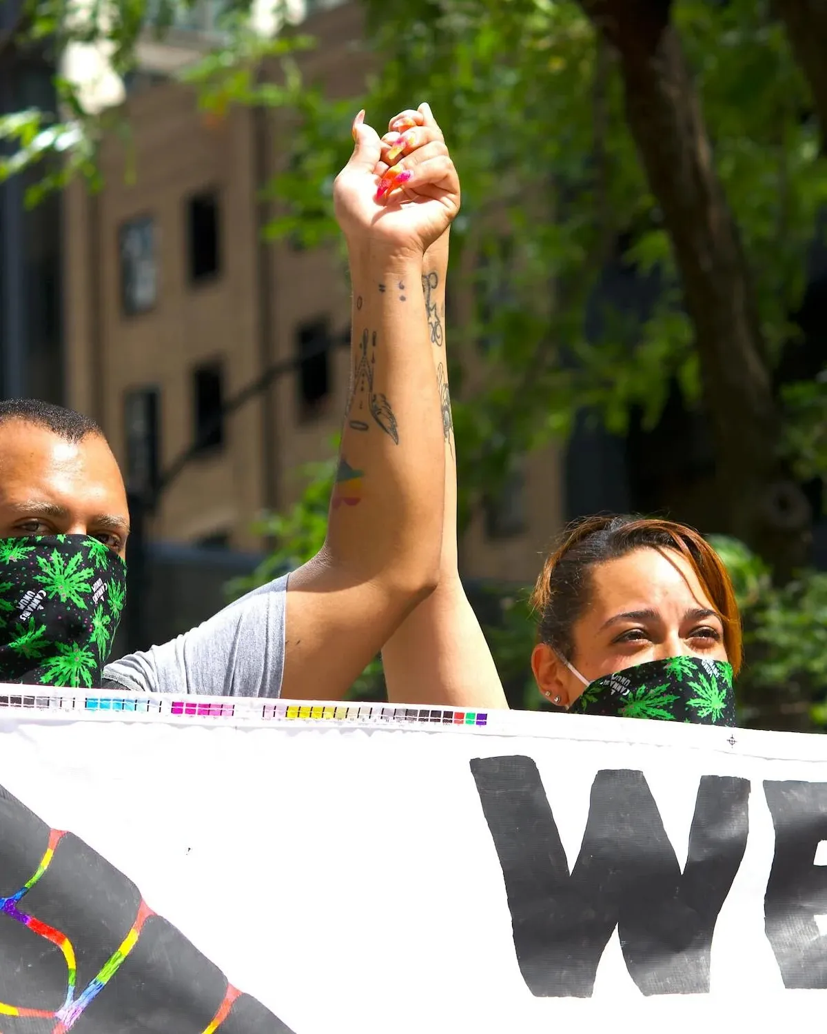 Dos manifestas alçen la mà en una concentració contra el racisme. 