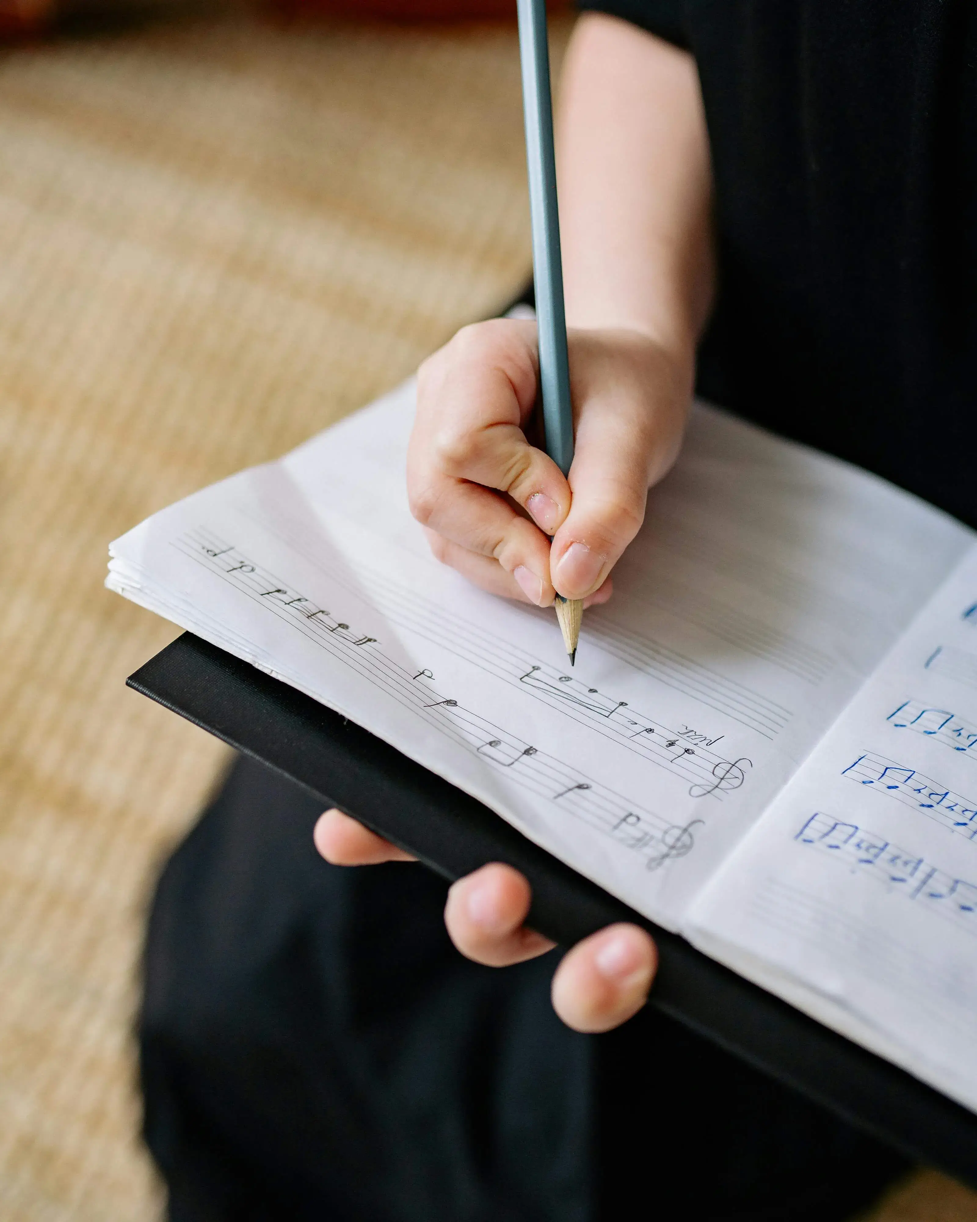 Persona escrivint en una partitura de música