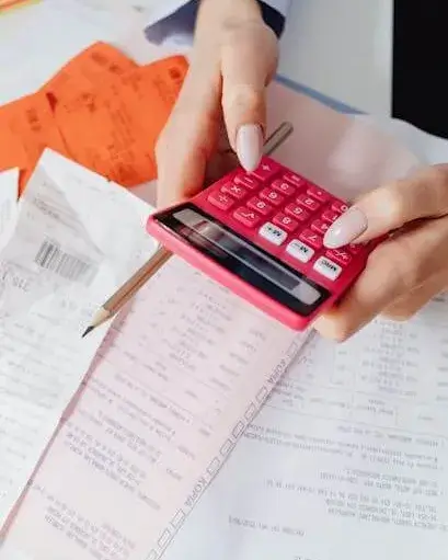 Finançament Persona amb documentació fent càlculs amb una calculadora