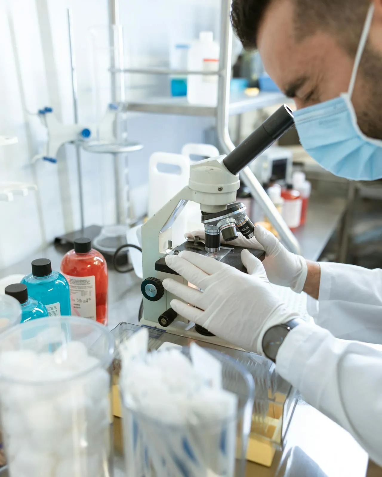 Home en un laboratori mirant per un microscopi Home en un laboratori mirant per un microscopi