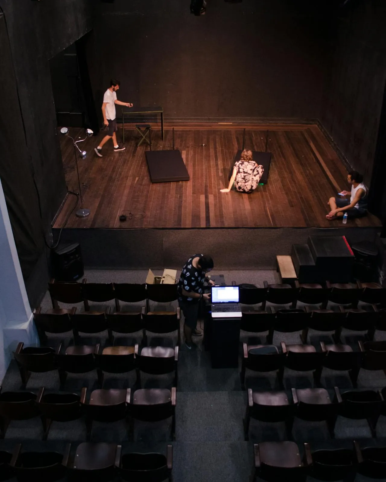 Vista zenital de les butaques i l'escenari d'un teatre amb gent treballant