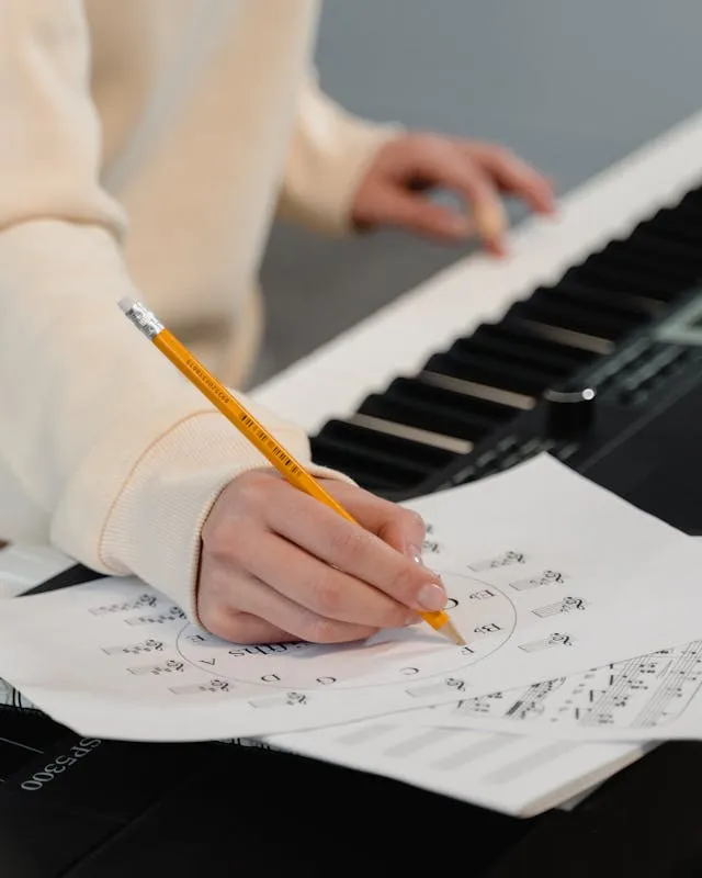 Persona amb un piano escrivint en una partitura