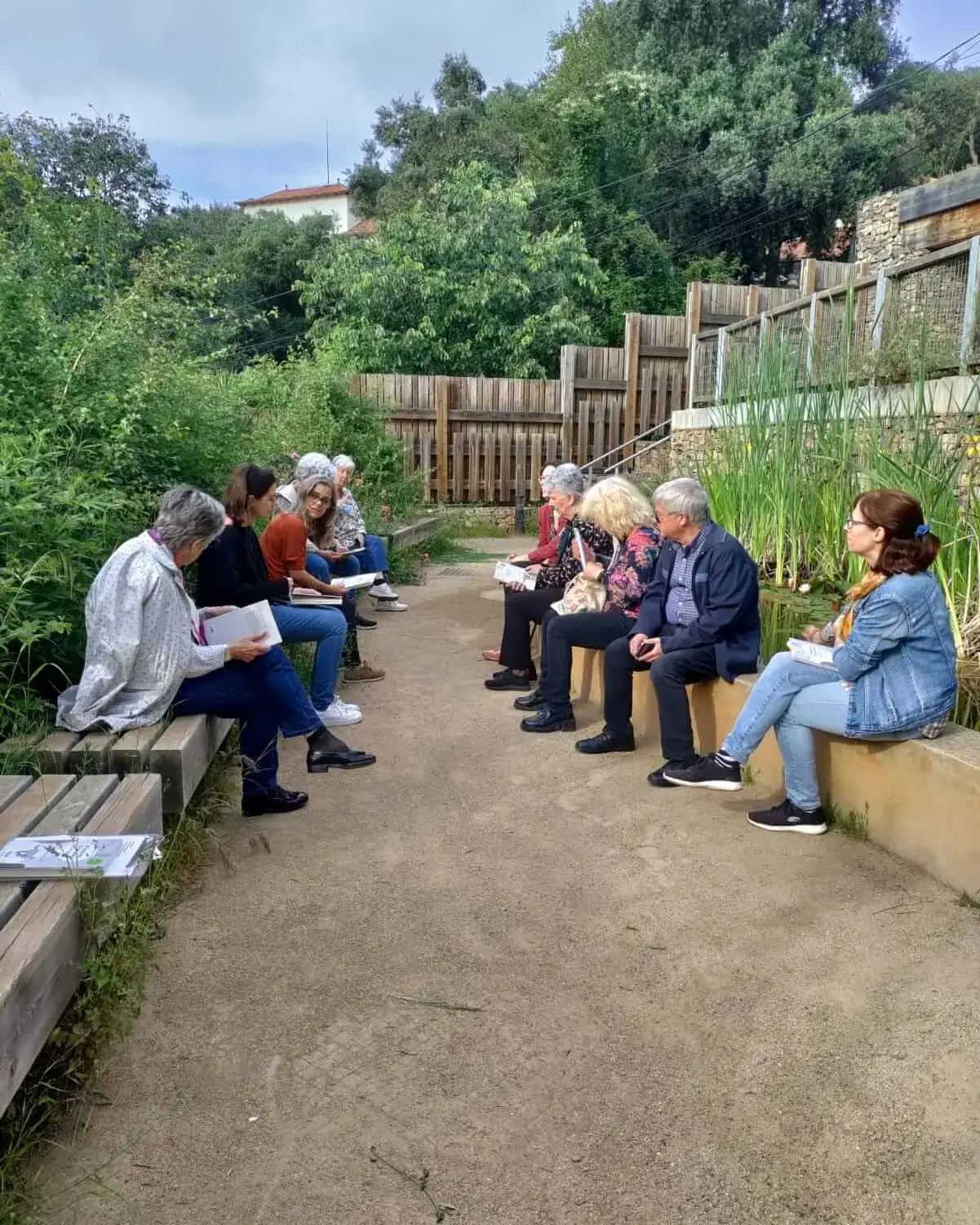 Fotografia de l'anterior lectura al bosc amb el grup de participants compartint reflexions a la vora de la bassa naturalitzada del Bosc Turull.