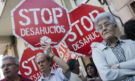 Fotografia de persones manifestant-se amb el rètol stop desahucios
