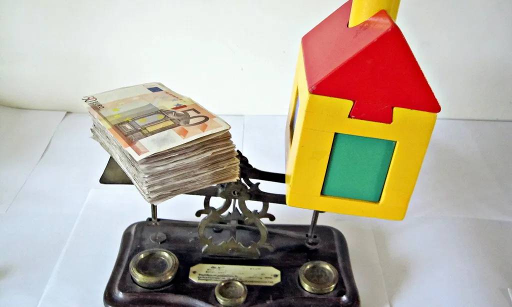 Diners i casa de joguina sobre una balança. Font: images_of_money (flickr.com)