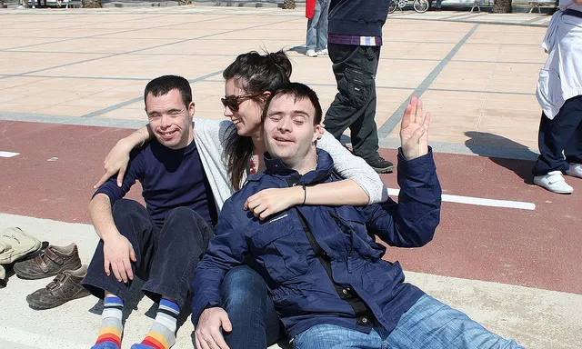 Monitor amb joves amb discapacitat intel·lectual fent una activitat en un pati d'escola