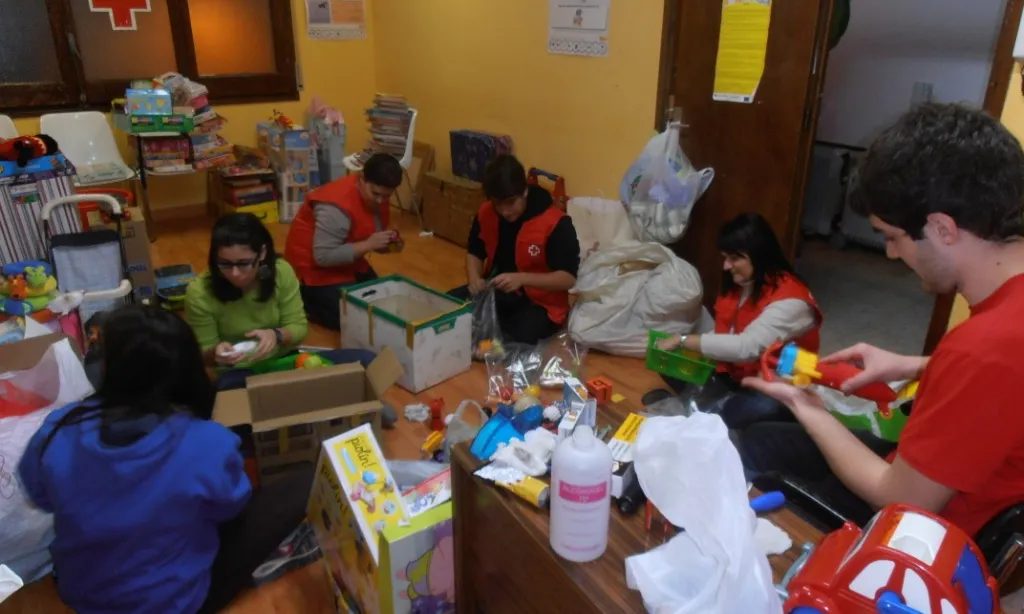 Voluntaris i voluntàries classificant joguines en una edició de recollida de Creu Roja