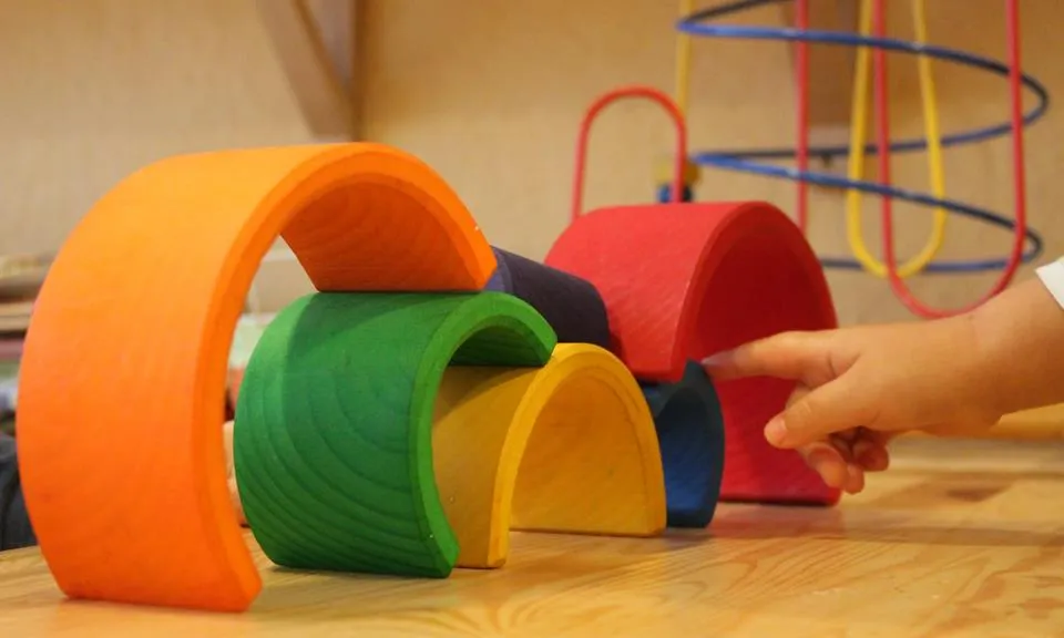 Materials per jugar de La Caseta amb la mà d'un infant que els toca (Font: La Caseta)