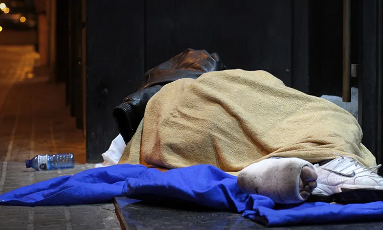 Una persona dormint al carrer. Font: Plana web d'Arrels Fundació