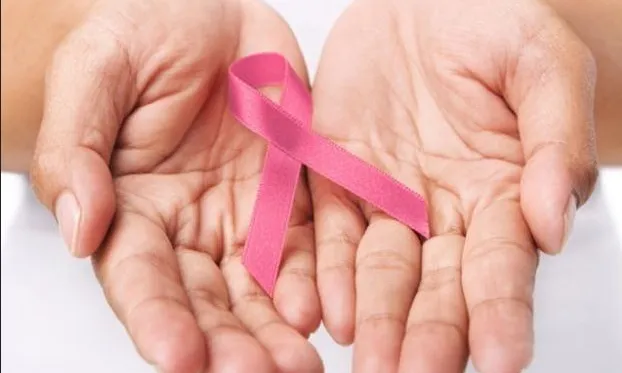 Unes mans amb un llaç de color rosa, símbol de la lluita contra el càncer 