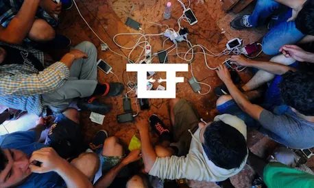 Persones refugiades amb material tecnològic.