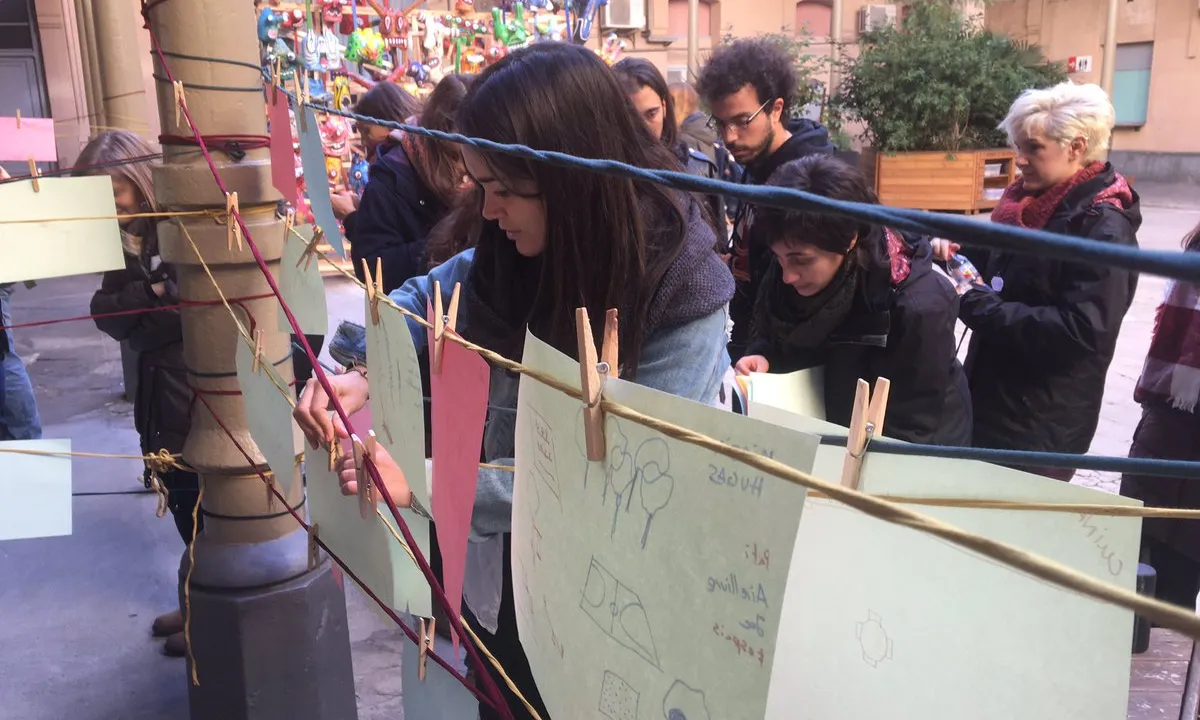 Sessió EdCamp amb persones fent dinàmica amb folis