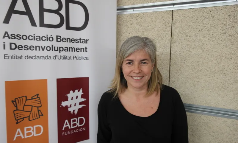 Carme Calafat al costat d'un cartell de l'entitat