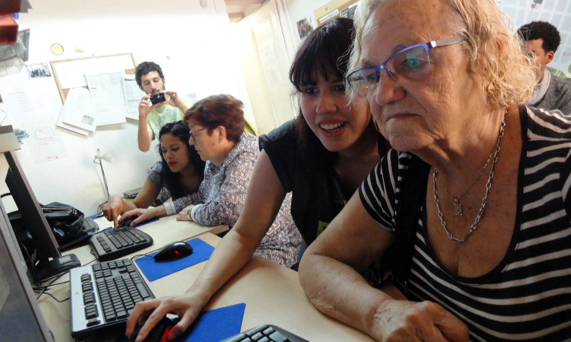 Una jove ensenya a fer servir l'ordinador a una senyora gran