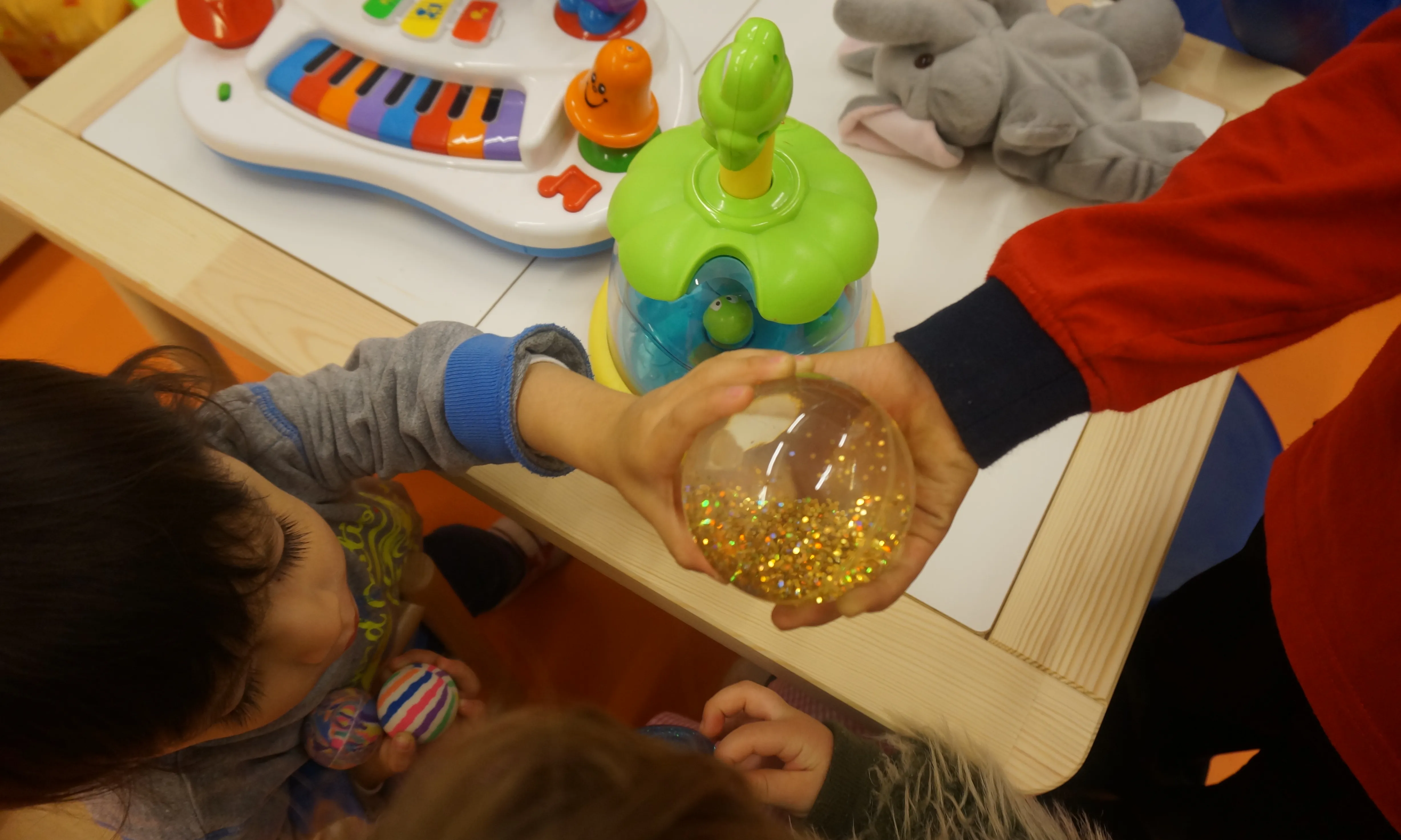 Infants jugant agafant una bola transparent amb les mans