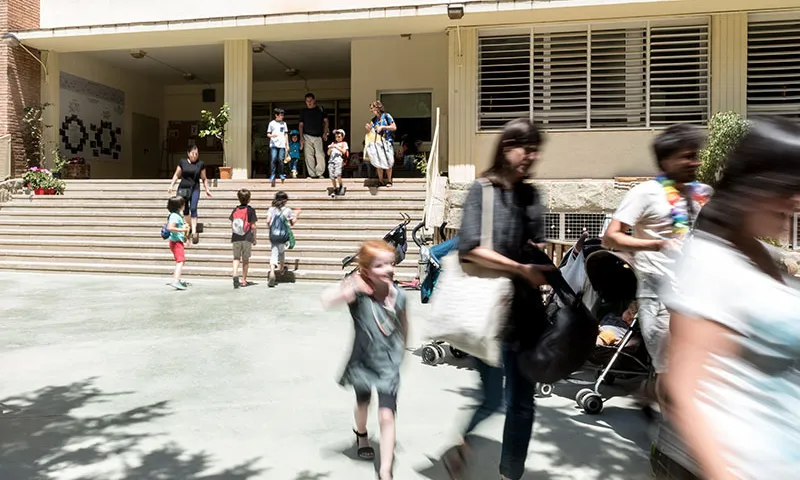 Famílies sortint d'un centre educatiu