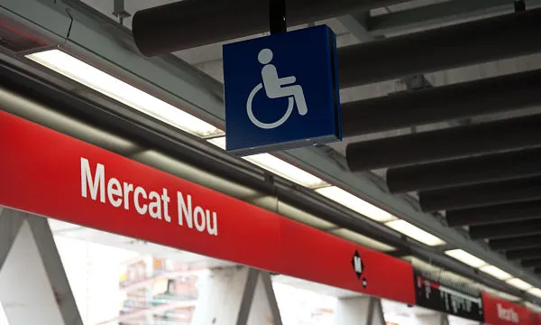 Imatge de l'andana de l'estació de metro Mercat Nou amb un símbol d'accessibilitat.