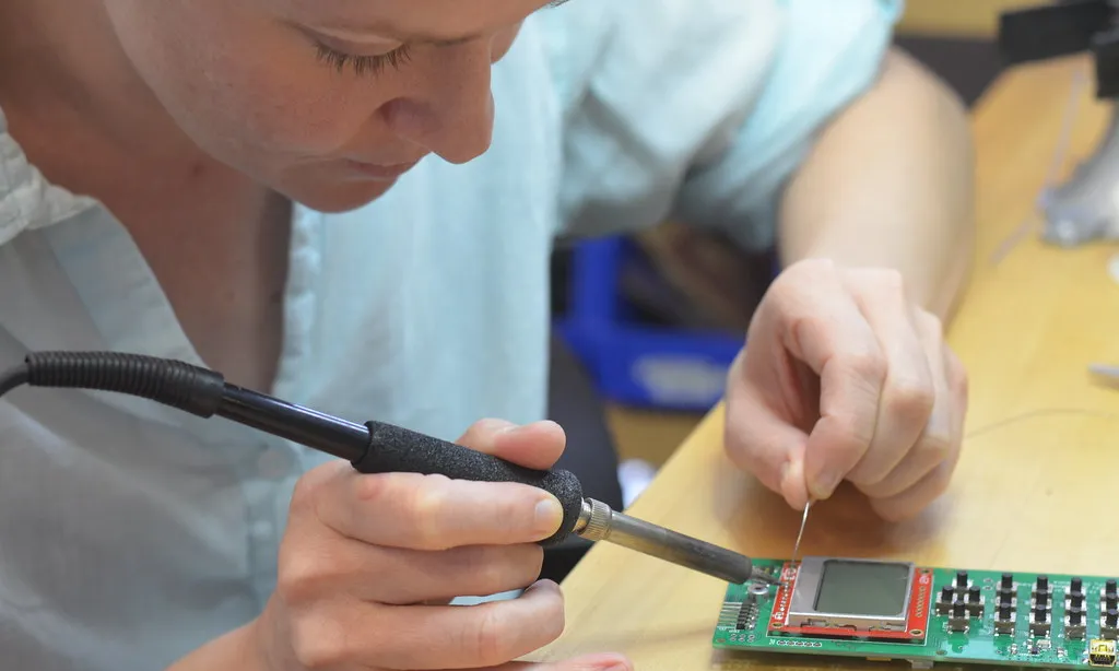 "Dena doing repairs on her phone" de dam (CC BY 2.0) 