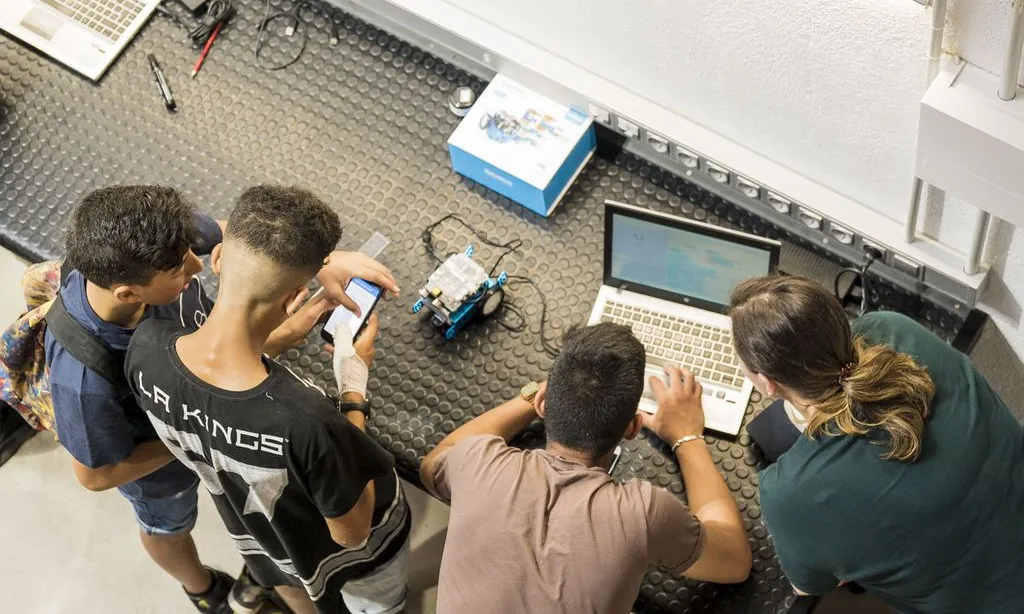 Joves treballant en un robot.