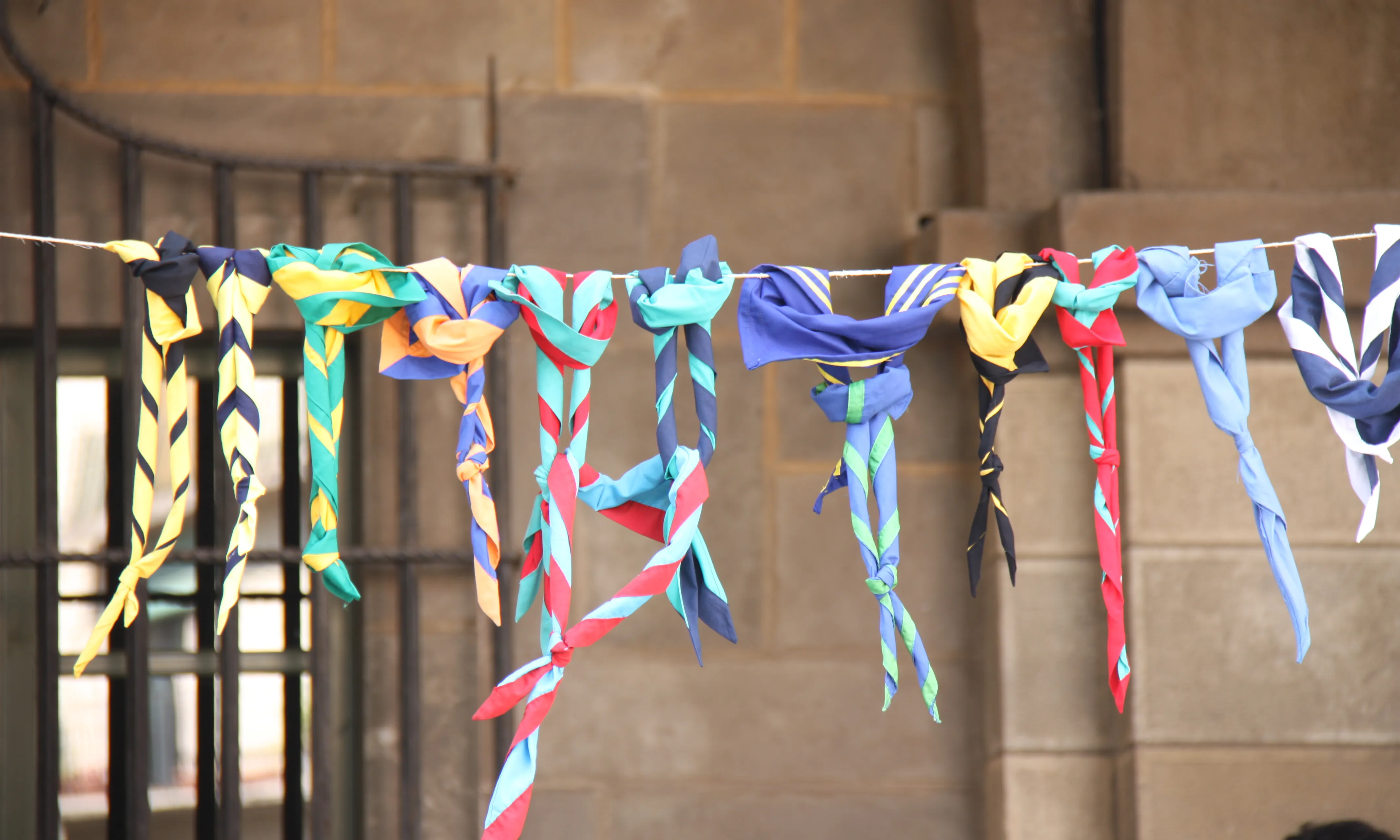 Exposició de fulards d'agrupaments escoltes de Catalunya penjats d'un fil.