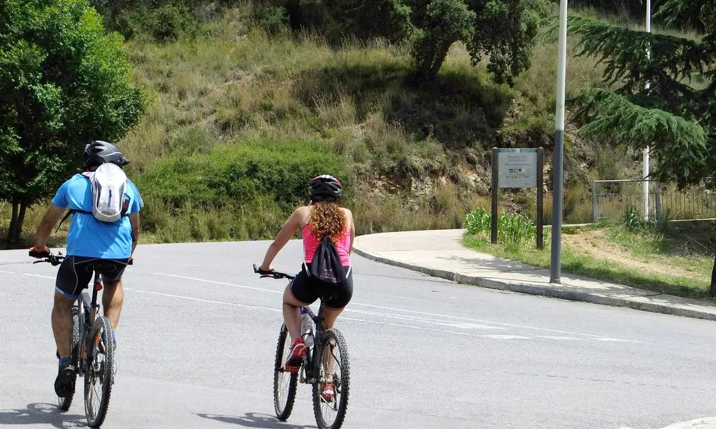 Dues persones en bici per la carretera Alta de les Roquetes de Barcelona.