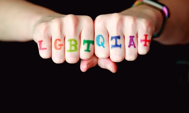 Foto d'unes mans amb la sigla LGBTQIA+ dibuixada a sobre.