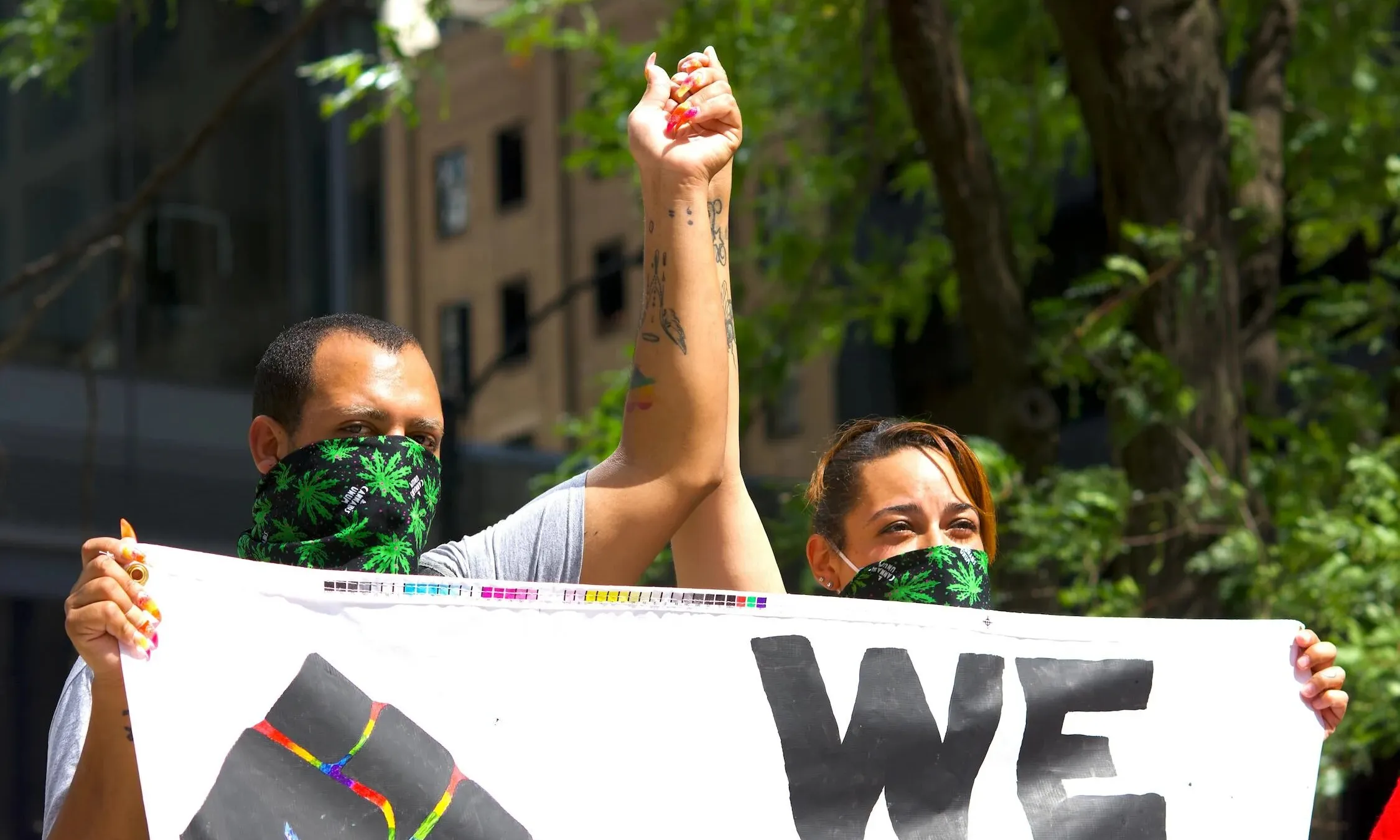 Dos manifestas alçen la mà en una concentració contra el racisme. 