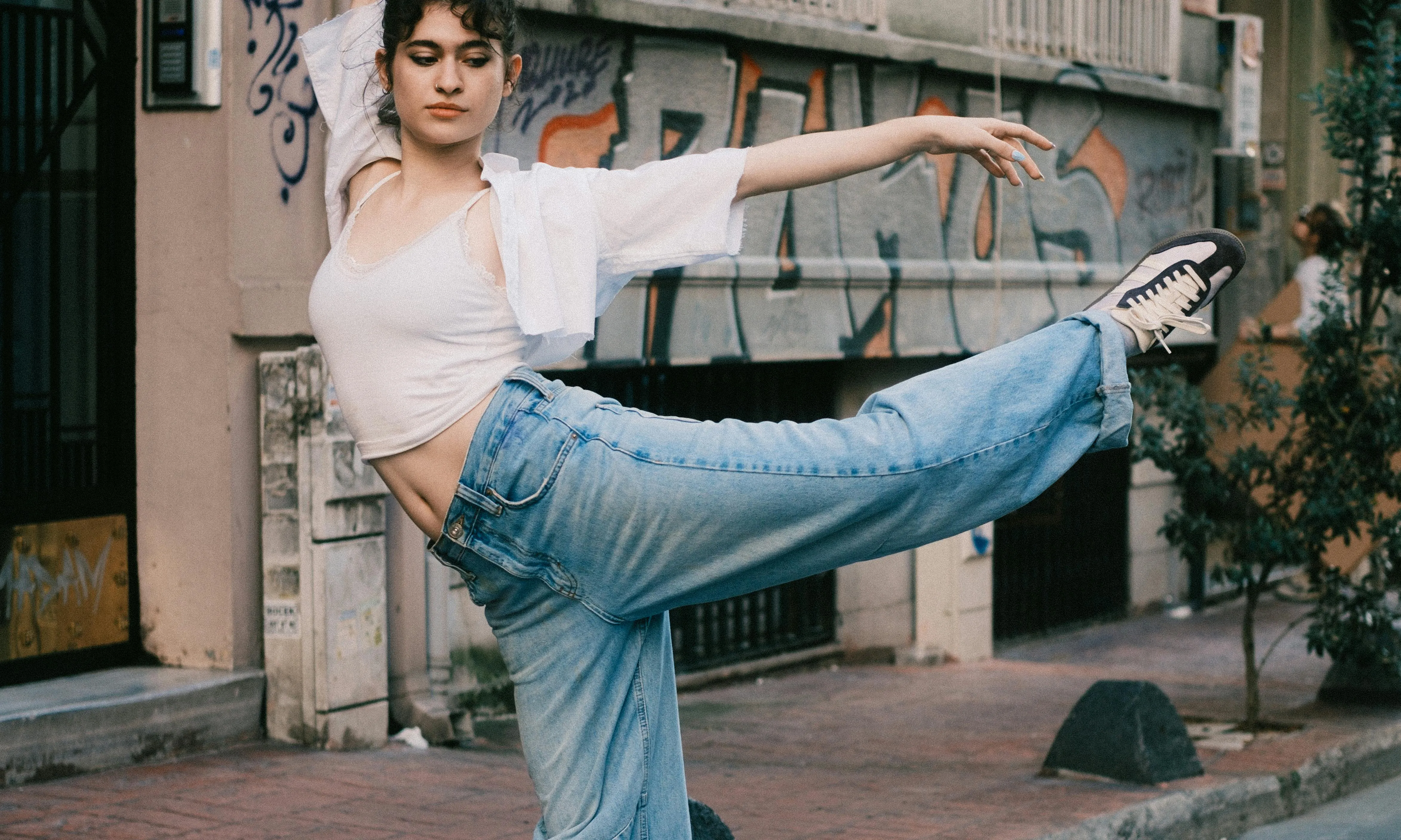 Ballarina de ballet urbà realitzant una postura de ball a l'aire lliure