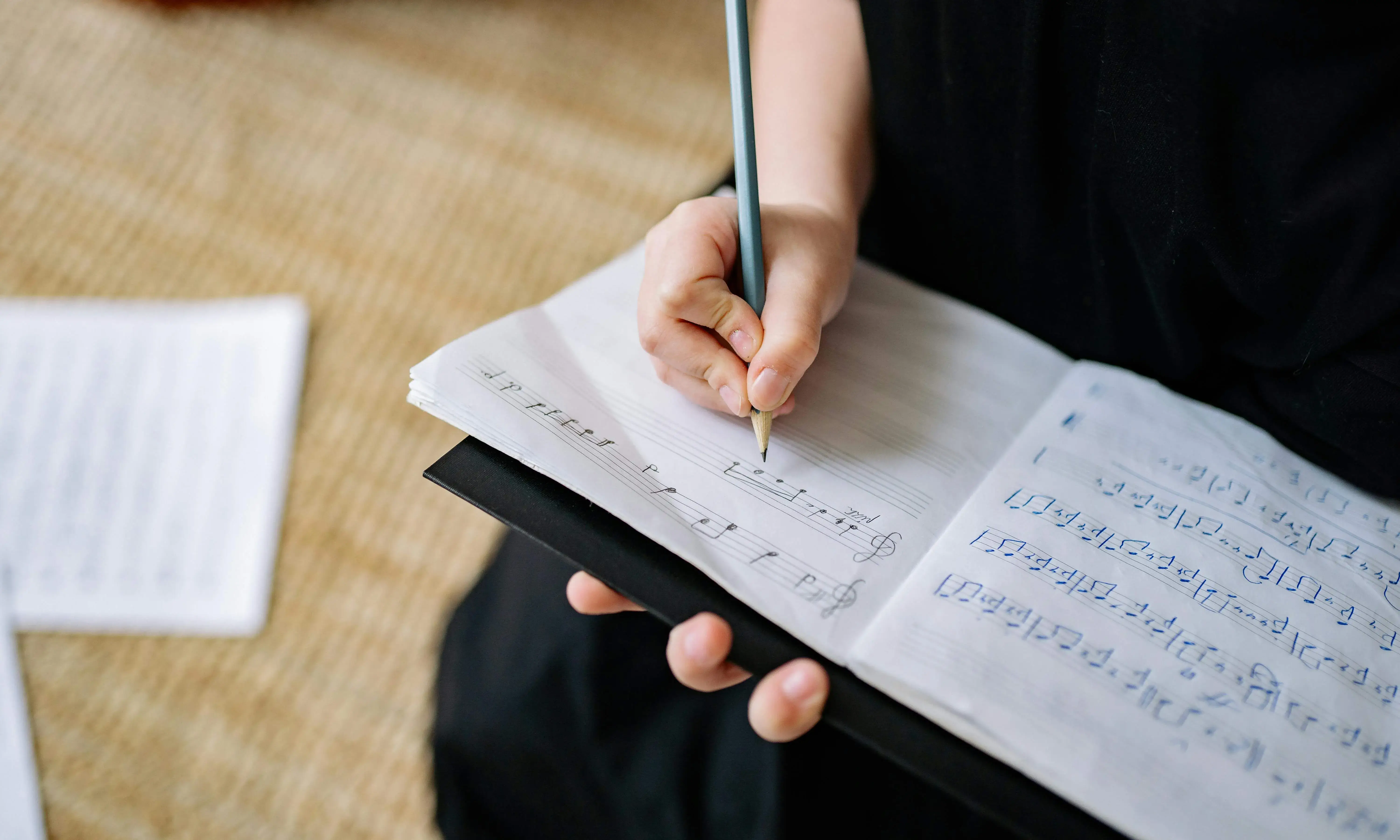 Persona escrivint en una partitura de música