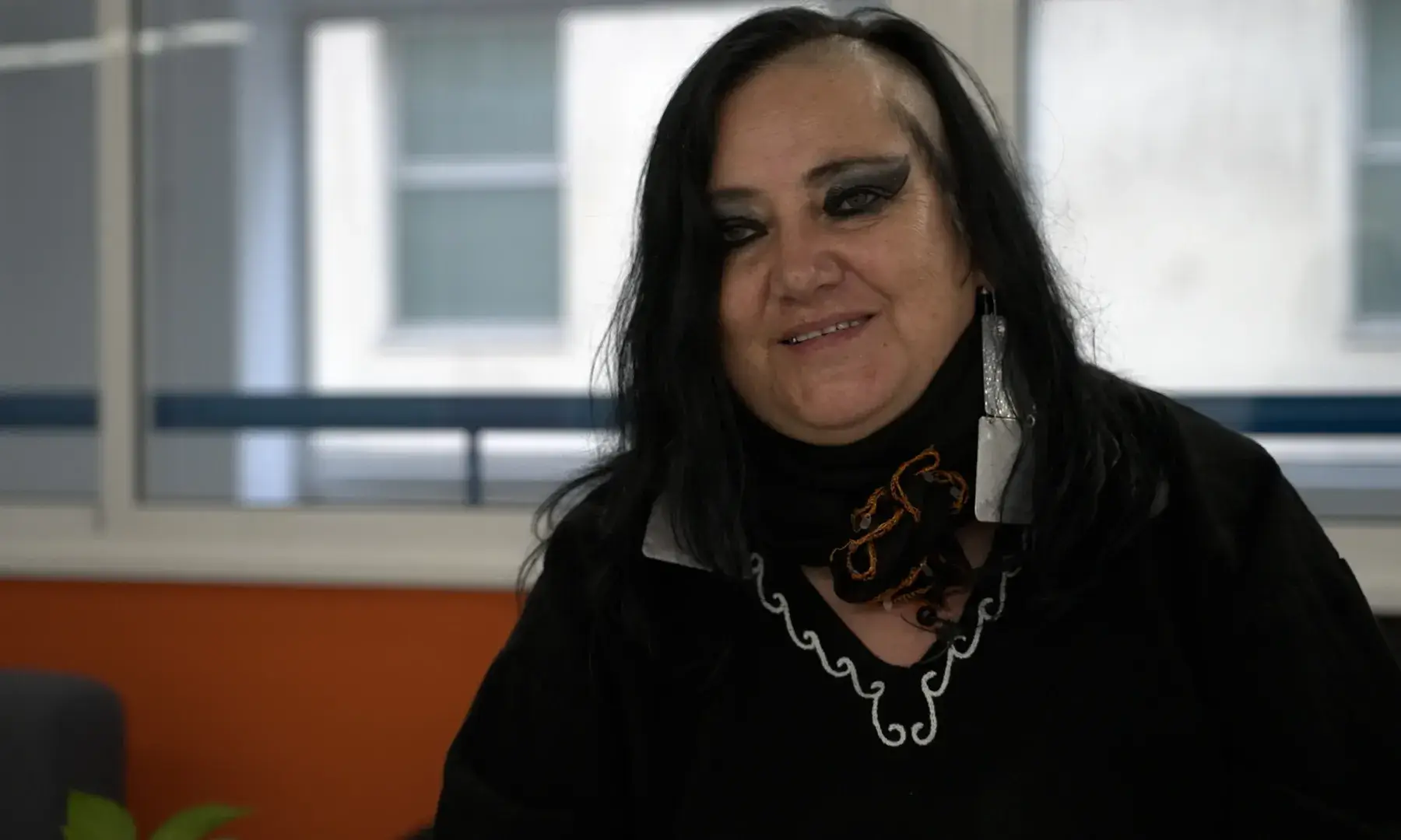 Retrat de la María Galindo, asseguda en una cadira i amb un pla americà.