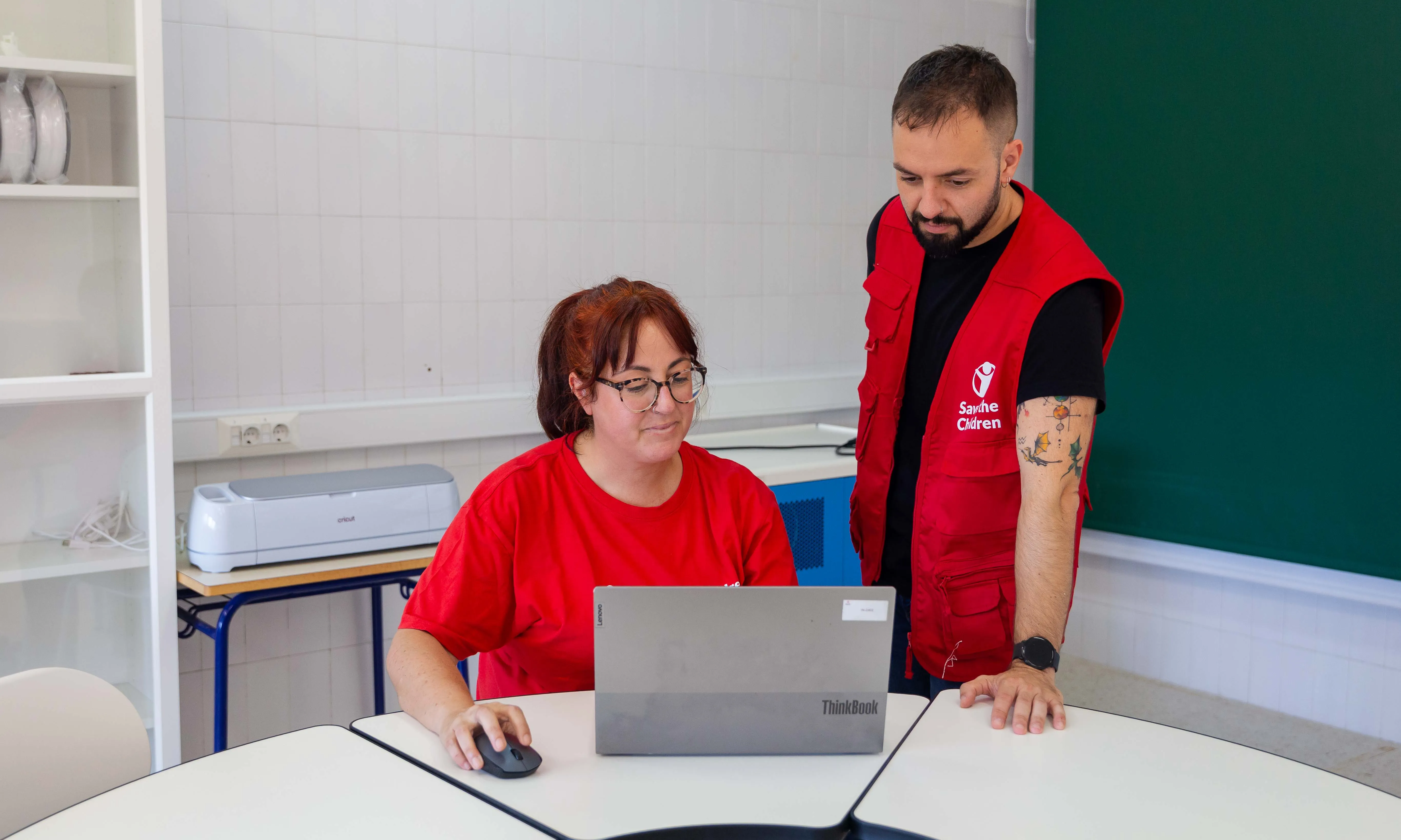 Educadora de Save The Children mirant un ordinador