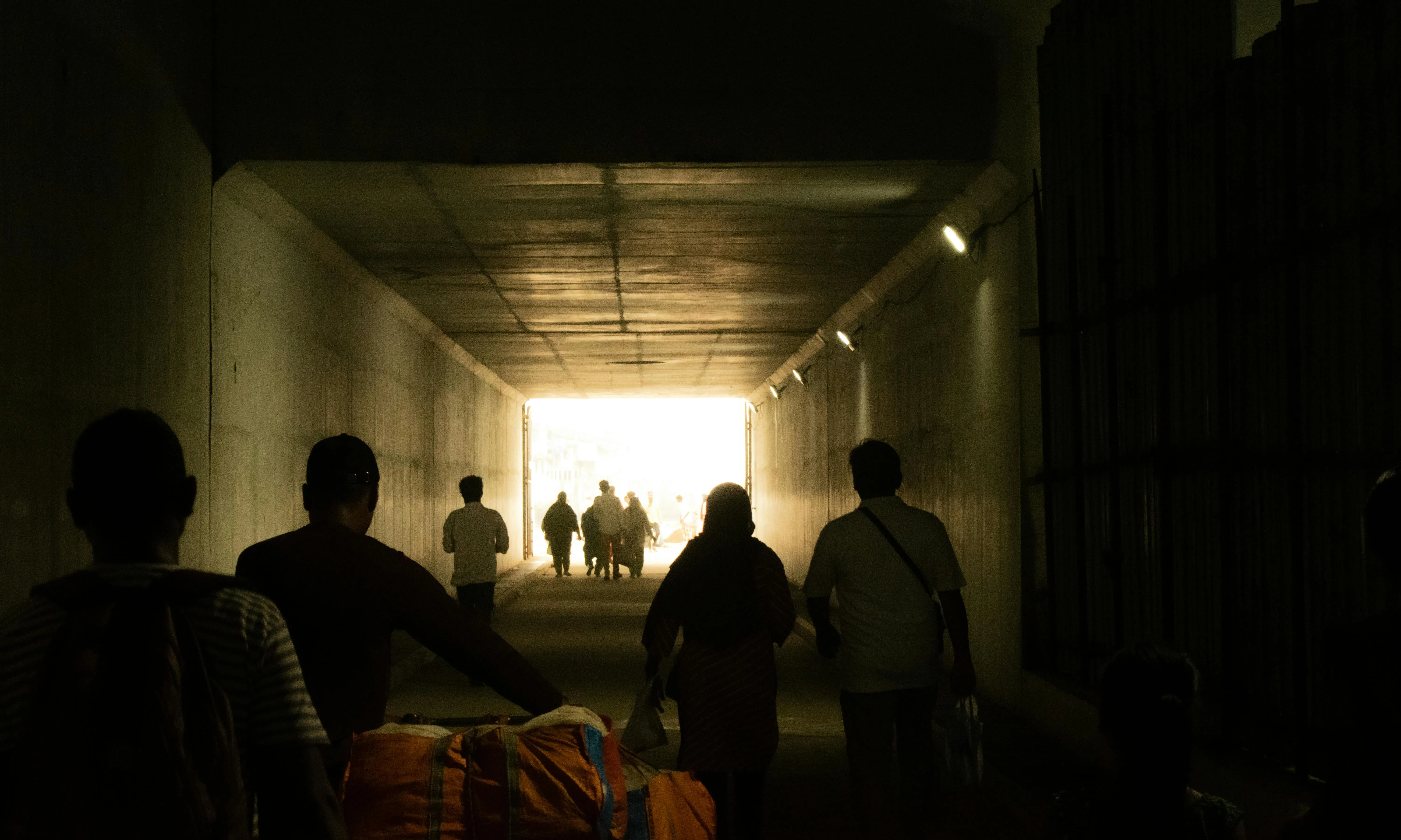 Persones migrants passant per un túnel 