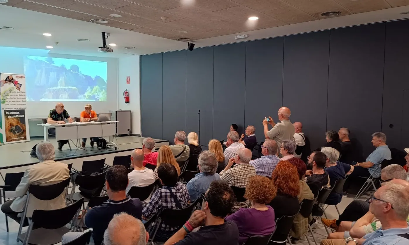 Una sala plena de persones assistint a una xerrada.