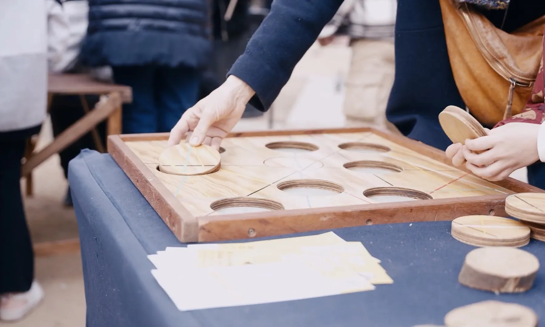 Imatge detall d'unes mans jugant a un joc d'omplir els forats amb les formes corresponents.