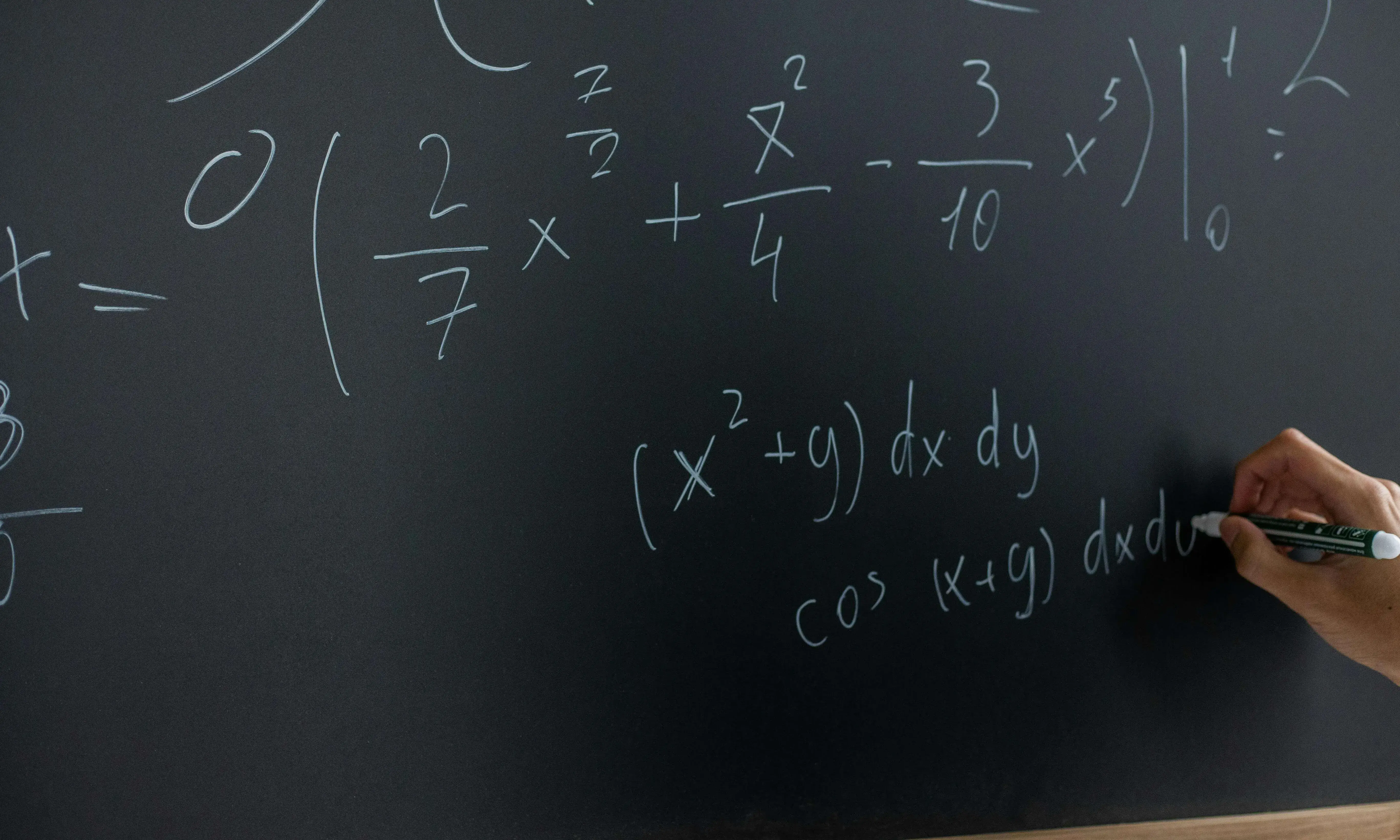 Mà escrivint fòrmules matemàtiques en una pissarra. 