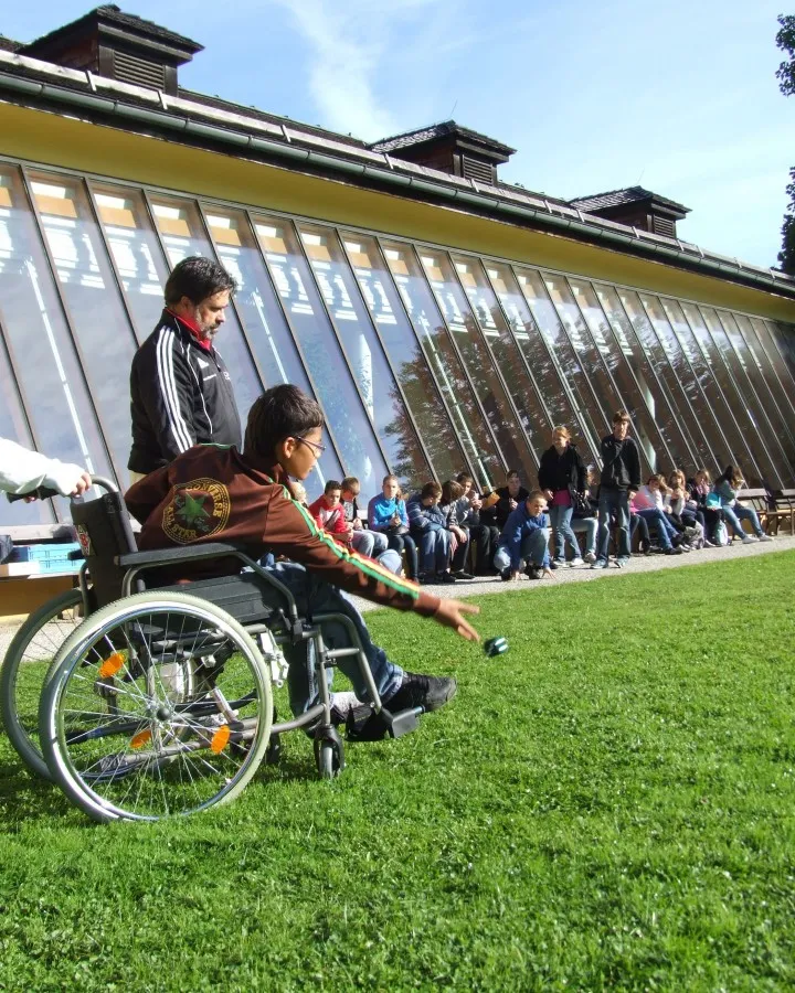 Un nen amb mobilitat reduïda participa a una activitat esportiva.