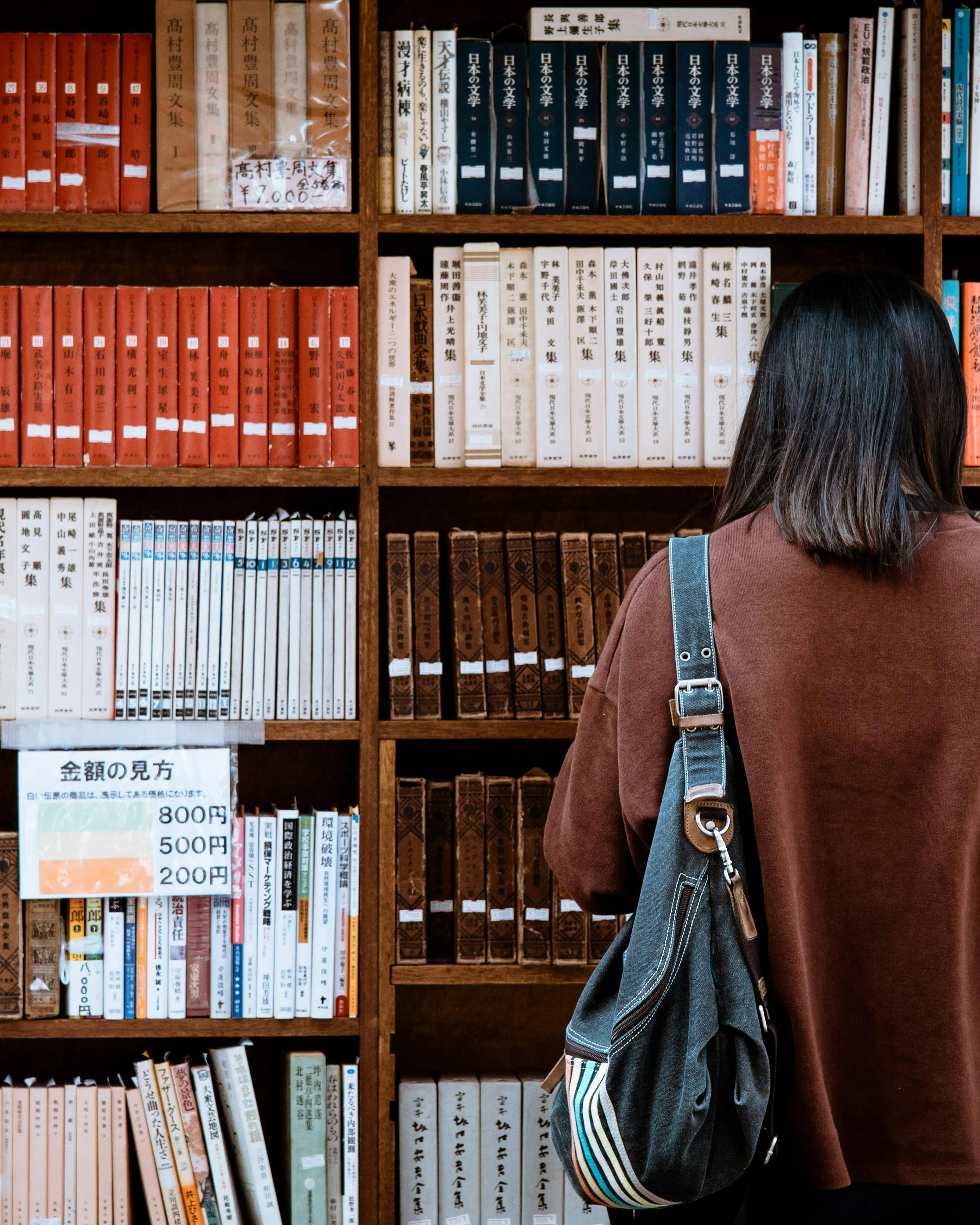 Persona consultant una biblioteca històrica. Font: Pexels - Abby Chung
