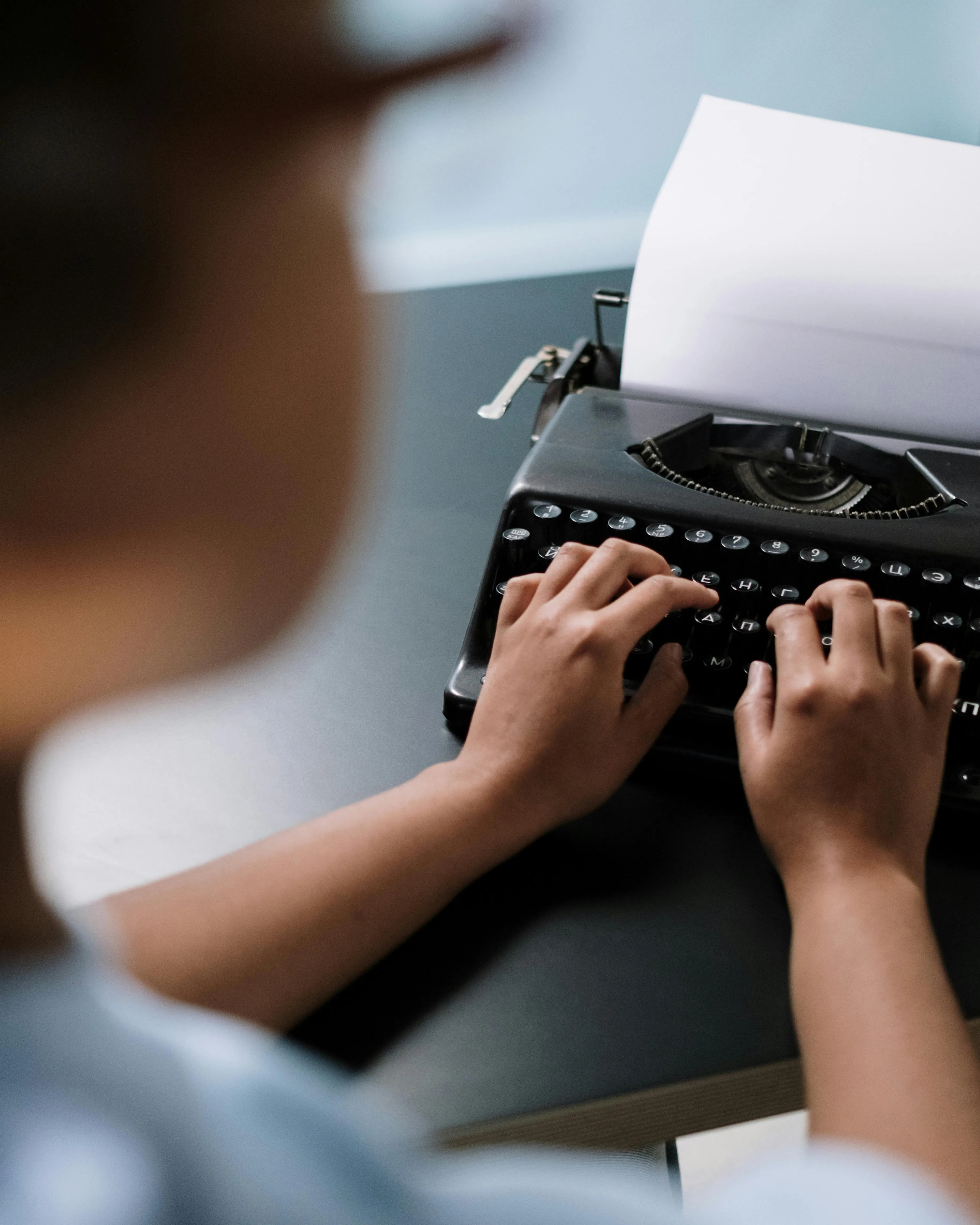 Persona escrivint amb una màquina d'escriure. 