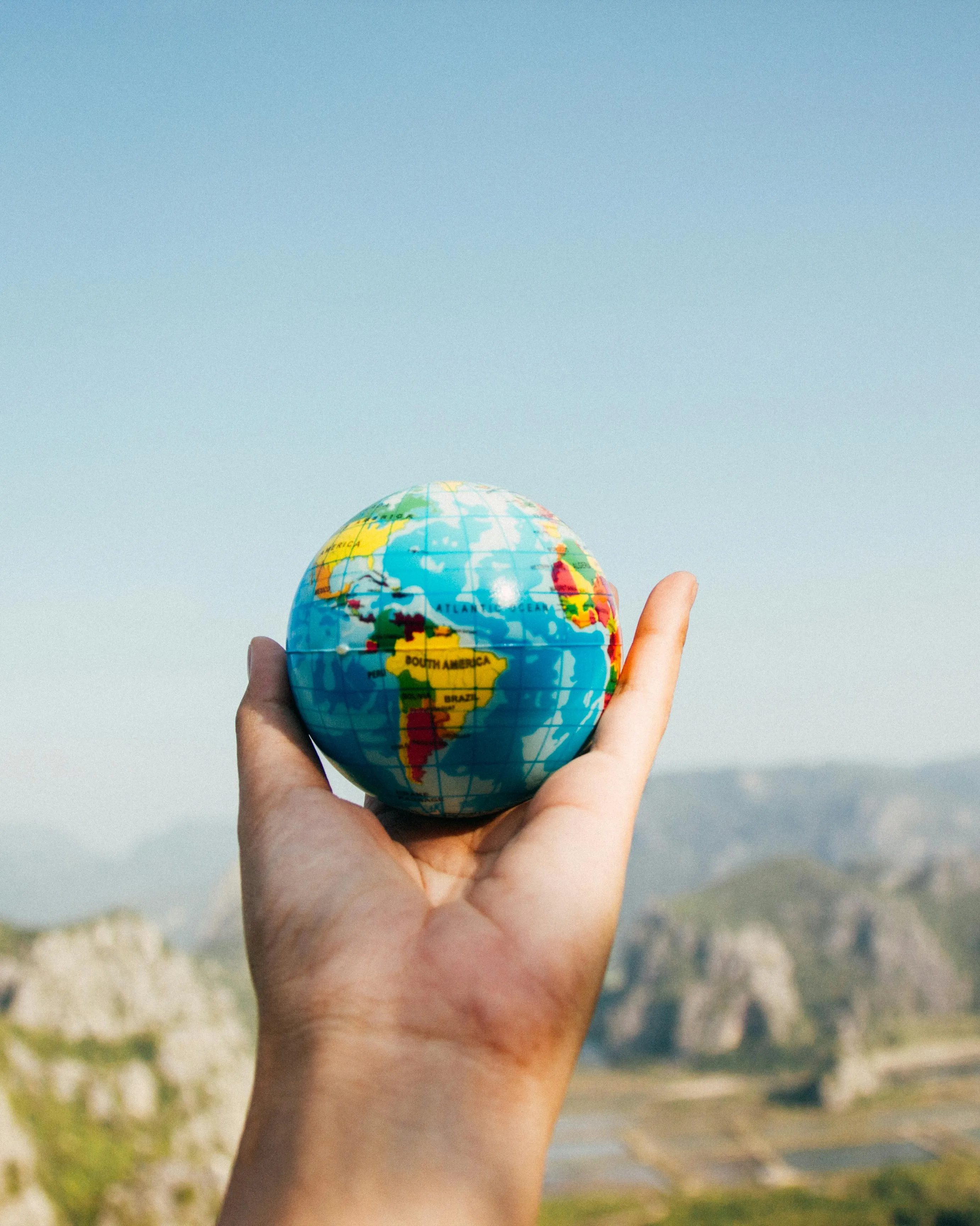 Mà sostenen un globus terraqüi. Font: Pexels - Porapak Apichodilok