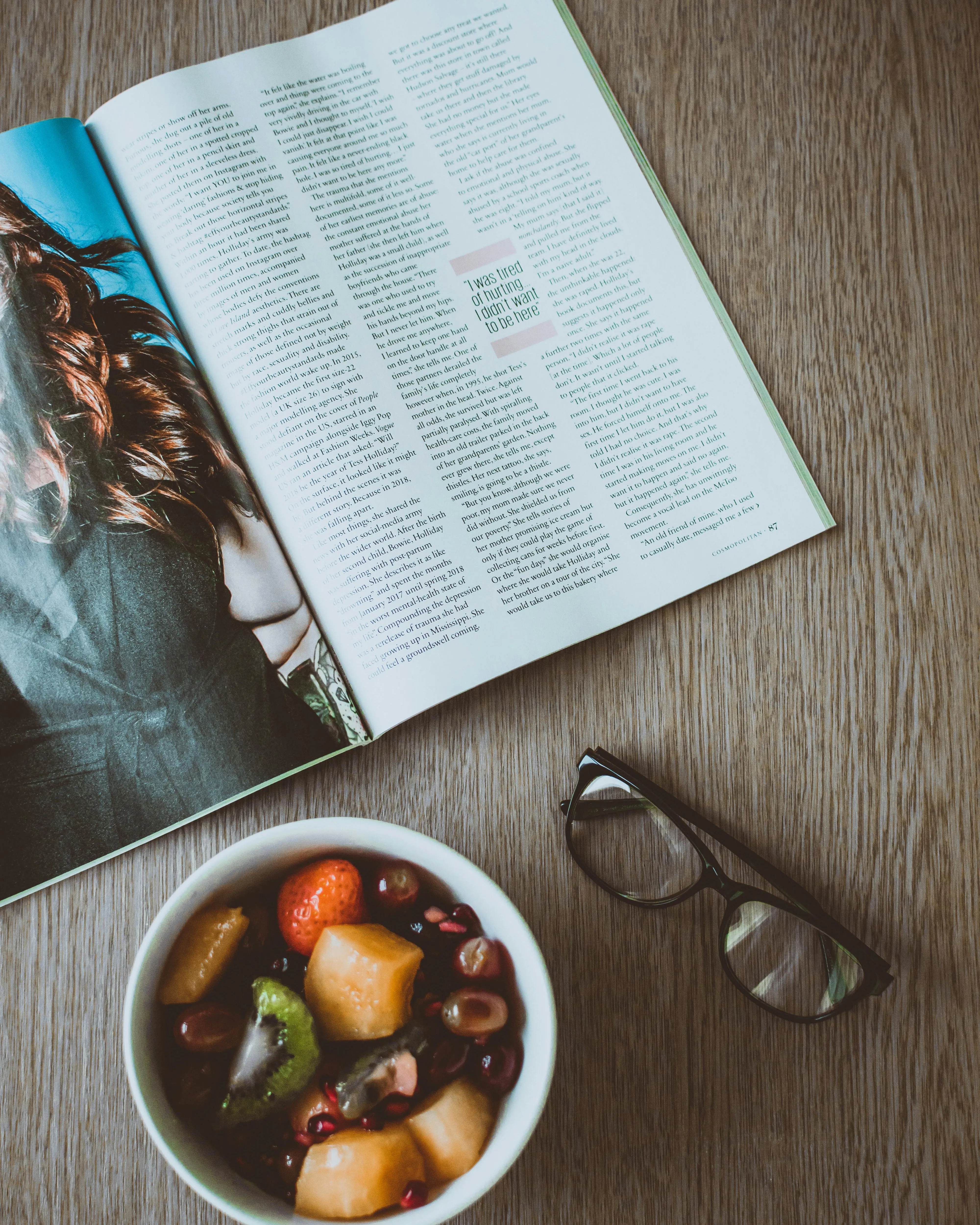 Taula amb una revista, unes ulleres i un bol amb menjar. Font: Pexels - Lisa Fotios 