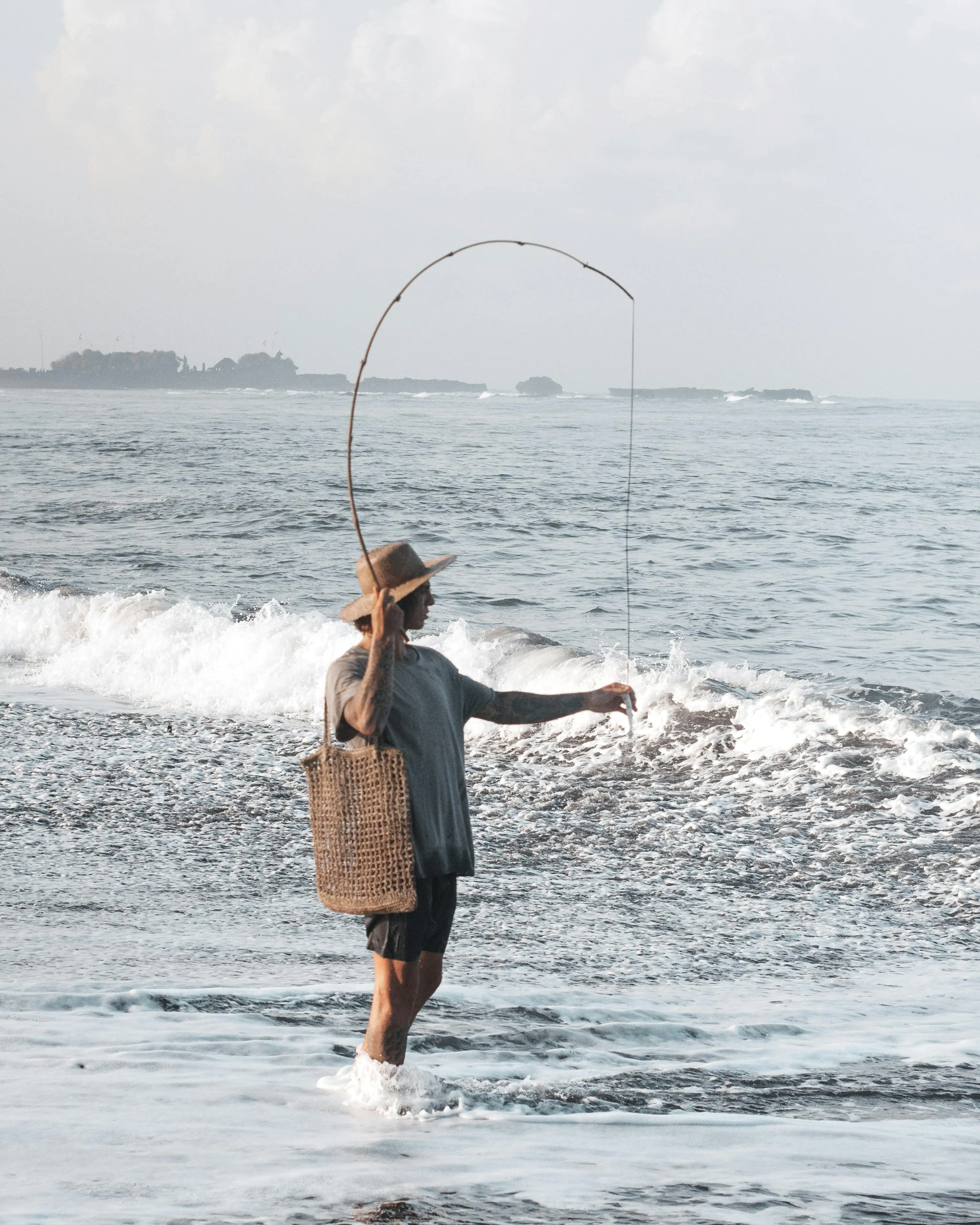 Noia pescant a la platja. Font: Pexels - ROMAN ODINTSOV