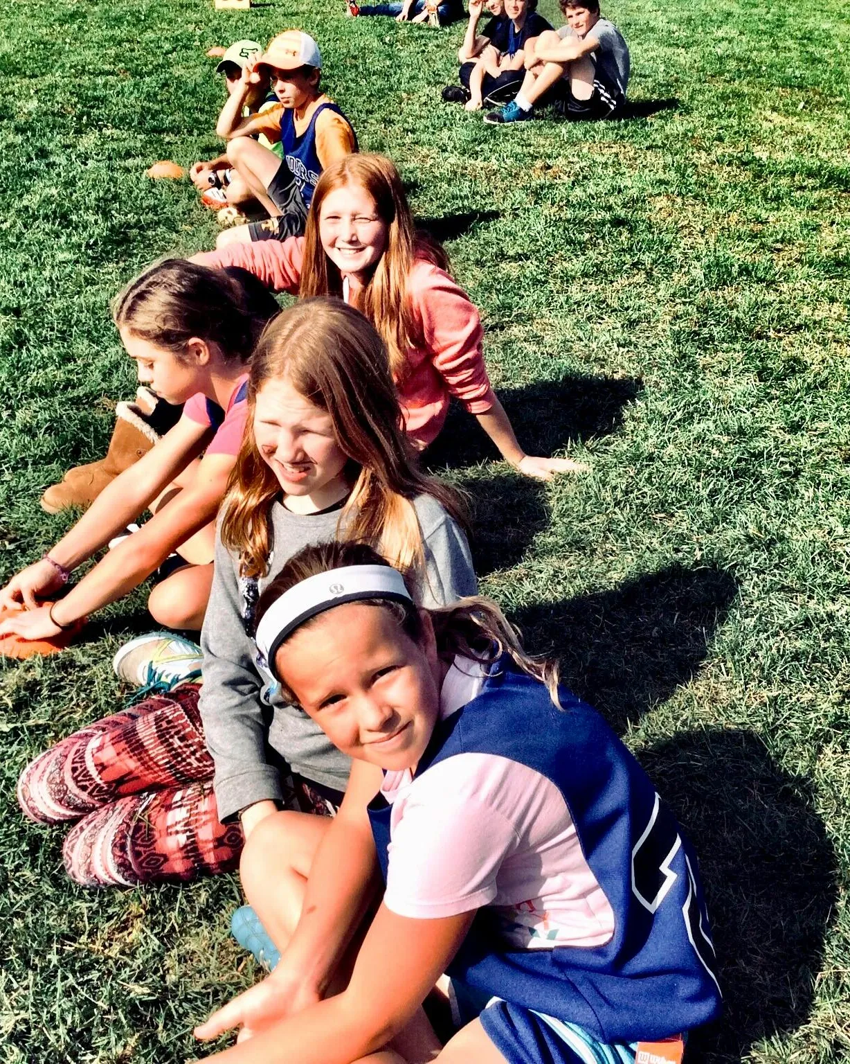 Infants asseguts en un camp de gespa. Font: Pexels - Anny Patterson