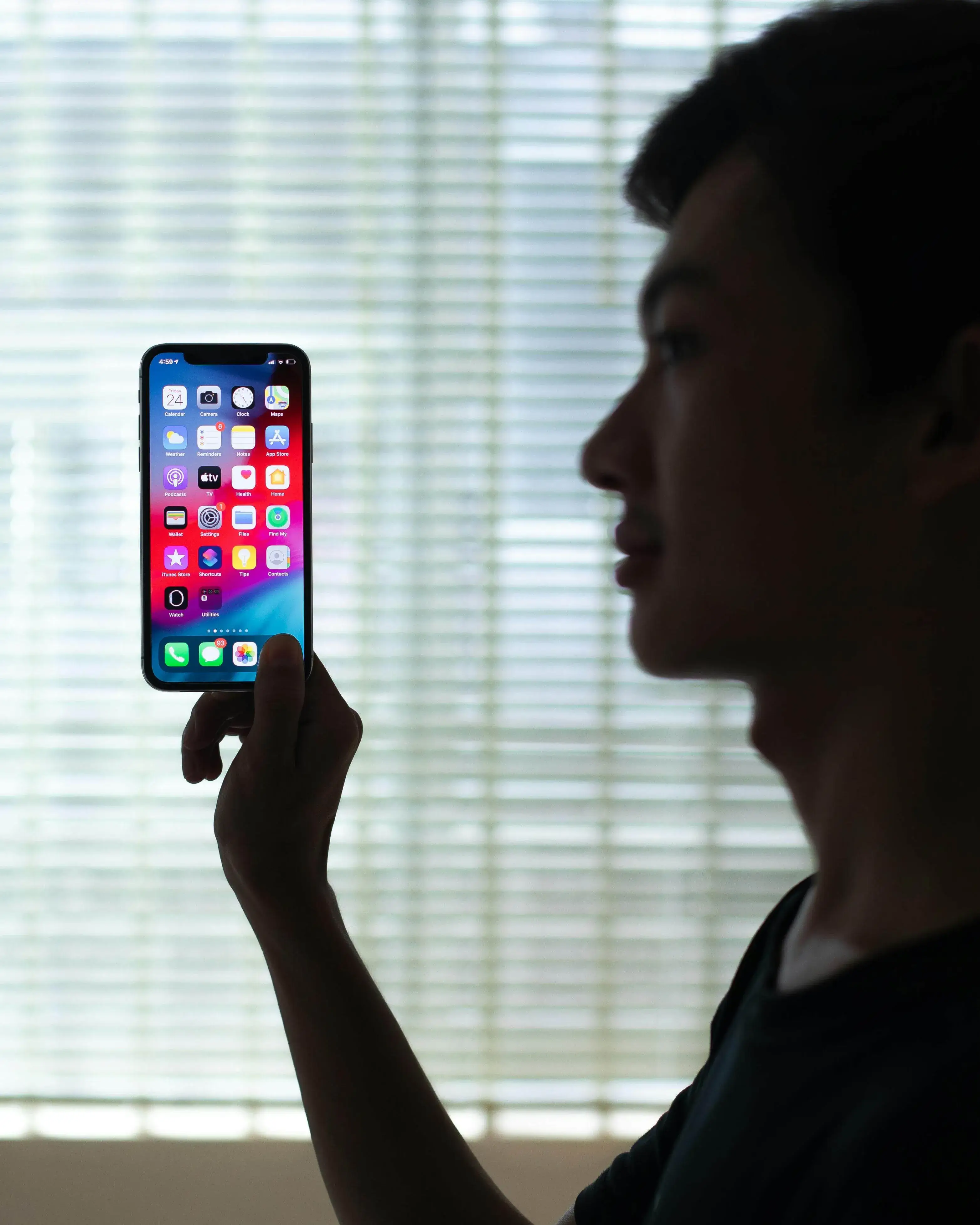 Silueta d'una persona subjectant un telèfon encès