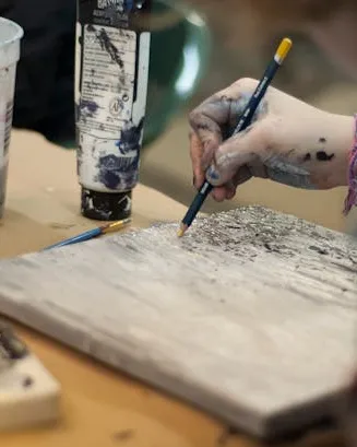Persona dibuixant amb diferents materials d'art